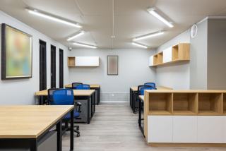 Bureaux opérationnels en bois clair avec sièges bleus et rangements muraux