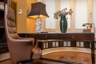 Fauteuil de direction en cuir brun à dossier haut dans un bureau classique