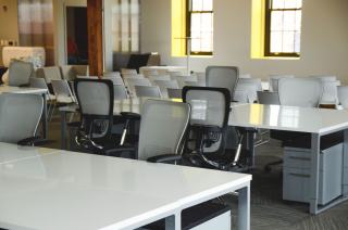 Rangées de bureaux blancs et de sièges résille dans un espace de coworking