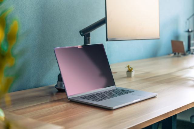 Bras d'écran, caissons, électrification : le mobilier bureautique technique Bras d'écran fixé sur un plan de travail en bois avec un ordinateur portable
