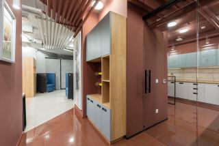 Armoires de rangement intégrées en bois et métal dans un couloir de bureaux