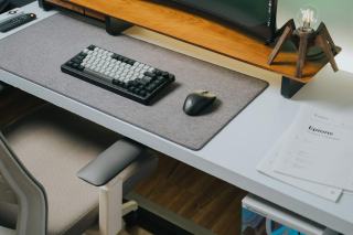 Clavier et souris posés sur un tapis de bureau devant un siège réglable
